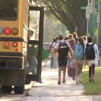 Des enfants débarquent d'un autobus scolaire lors de la rentrée à l'École canadienne-française de Saskatoon, en Saskatchewan, le 3 septembre 2024.