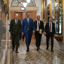 M. Roberge marchant dans un couloir de l'Assemblée nationale avec les députés Tanguay, Leduc et Paradis.