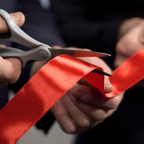 Des gens coupent un ruban rouge pour une inauguration.