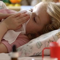 Une fillette malade est couchée dans son lit.