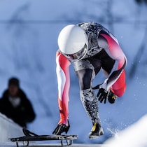 Un athlète de skeleton s'élance vers la piste. 