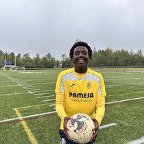 Silvain Masimengo, ballon en main, devant un terrain de soccer.