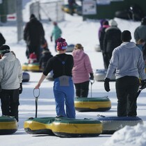 Des jeunes dehors tiennent leur tube à neige.