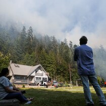 Gurtmit Khattra et sa femme observent une fumée épaisse issue du feu depuis leur maison.