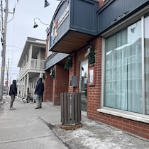 Des personnes en situation d'itinérance devant la Tablée populaire au centre-ville de Drummondville.