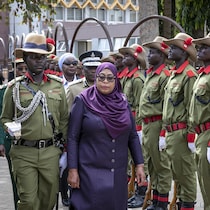 Une femme marche devant une rangée de soldats.