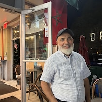 Driss Lazhar devant l'entrée de son restaurant.