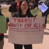 Trois manifestants tiennent des pancartes dans leurs mains.