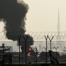 La ligne d'horizon de Dubaï, avec l'emblématique gratte-ciel Burj Khalifa (à droite), est photographiée alors qu'un panache de fumée s'élève d'un incendie en cours près de l'aéroport international de Dubaï.