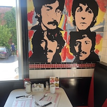 Affiches du groupe de musique The Beatles au-dessus d'une table du restaurant Paulo et Suzanne, à Montréal.