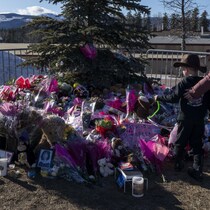 Une mère et son fils se sont rendus, le 14 février, devant un mémorial pour rendre hommage aux victimes de la tuerie de Tumbler Ridge, en Colombie-Britannique.