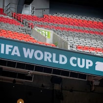 Des gradins où un panneau indique, en anglais « coupe du monde de la FIFA 2026 ». 
