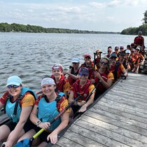 Des membres de l'équipe Vise-à-vie sont assises dans un bateau-dragon.