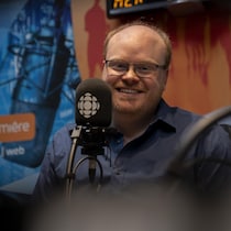 Il est dans un studio de radio, souriant.