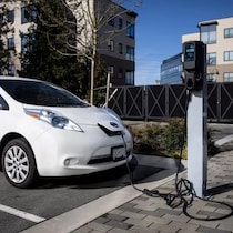 Une station de recharge pour véhicules électriques dans une place de stationnement.