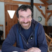 Yann Quenet sourit près d'un chalet en Abitibi.