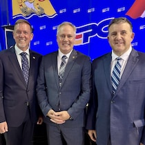 Don Monahan, Glen Savoie et Daniel Allain sont côte à côte devant les médias.