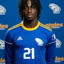 Joueur de soccer devant un logo des Aigles Bleus