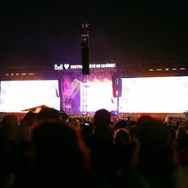 La foule regarde une scène avec deux écrans géants.