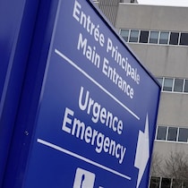 Une enseigne pointant l'entrée de l'urgence et le bâtiment de l'hôpital.