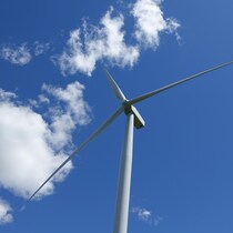 Une éolienne sur fond de ciel bleu.
