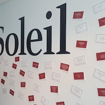 Des messages épinglés sur un mur autour du logo du quotidien Le Soleil.
