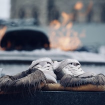 Une paire de mocassins devant la flamme du Centenaire.