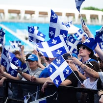 Une foule arborant plusieurs drapeaux du Québec.
