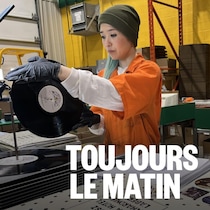 Une femme qui presse un vinyle d'Angine de Poitrine. 
