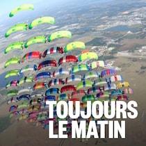 Des parachutistes se tiennent en formation dans les airs.