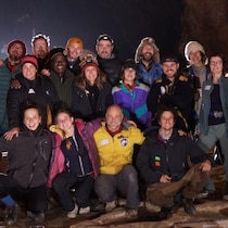 Un groupe de personnes posent pour une photo dans une grotte.