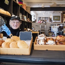 Une femme âgée qui travaille dans une boulangerie.