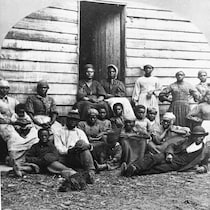Des anciens esclaves posent devant un refuge temporaire à Arlington, en Virginie, au milieu des années 1860.