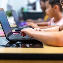 Des élèves d'école primaire devant des ordinateurs portables.