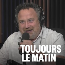 Jean Lamarche parle devant un micro en souriant.