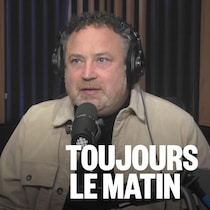 Jean Lamarche parle devant un micro. 