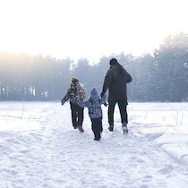 Une famille court dans la neige.