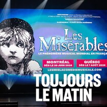 Une scène avec l'affiche de la comédie musicale Les Misérables à l'arrière-scène.