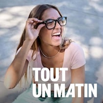 Une femme tient la monture de ses lunettes, devant une personne qui fait le signe de paix avec les doigts.