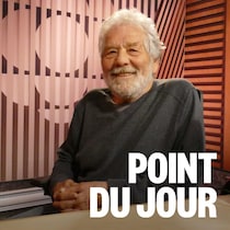 Un homme au micro sourit. 