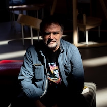 L'auteur est assis dans le noir.