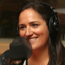 Photo de Caroline Huard devant un micro de radio.