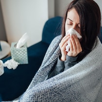 Une femme malade se mouche.