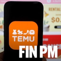 Une main tient un cellulaire affichant l'application Temu.