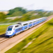 Un train à grande vitesse passe à travers un champ en France.