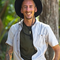 Un homme souriant avec un chapeau.