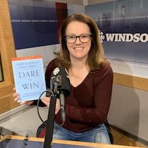 Chantal Vallée dans un studio de CBC avec son livre Dare to win en main 