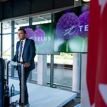 Evan Solomon debout devant un micro lors d'un point de presse.