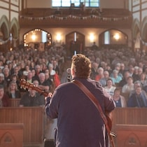 Un musicien sur scène devant une foule.