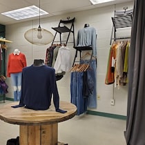 Un local où plusieurs vêtements y sont accrochés.